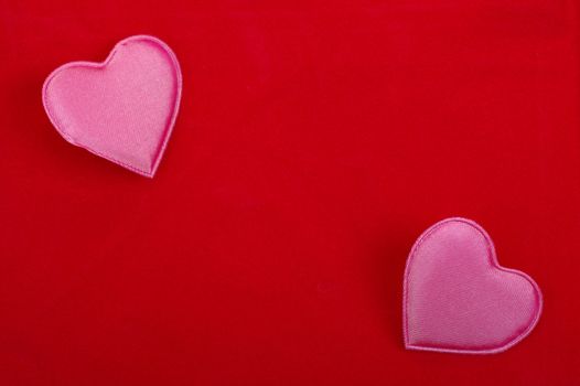 Two pink hearts isolated on red textured background. Empty space for your design.