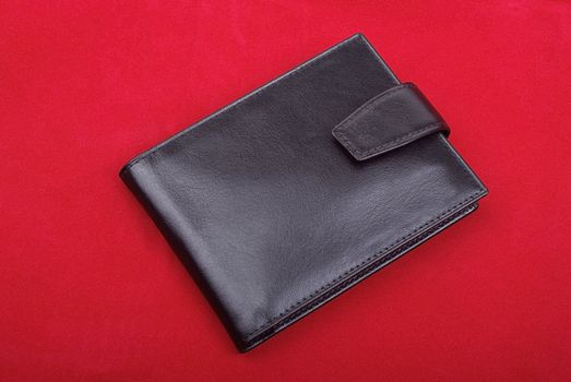 High quality black leather wallet isolated on red background. Studio shot.