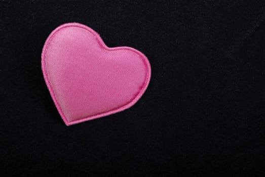  Pink heart macro isolated on black velvet background. Empty space for your design.