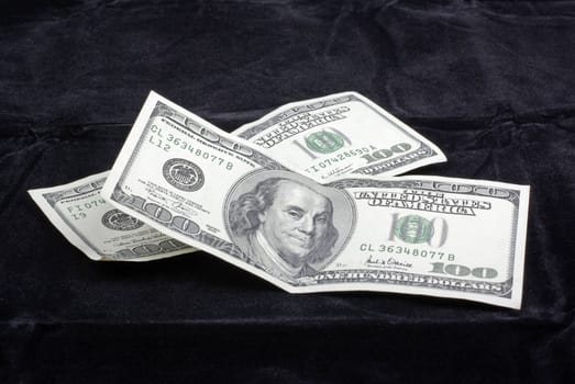 US Dollar currency banknotes isolated on black velvet background.