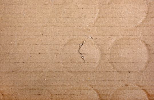 Brown damaged cardboard with bottle traces as background.