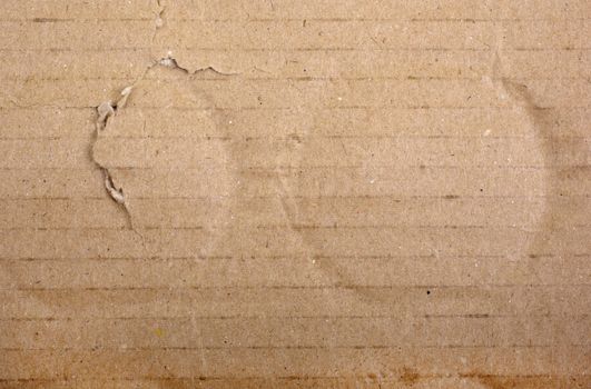 Brown damaged cardboard with bottle traces as background.