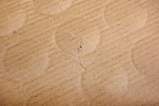 Brown damaged cardboard with bottle traces as background.