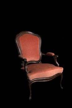 antique red armchair on a black background