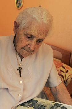 senior woman, 92 years old, looking an album photos