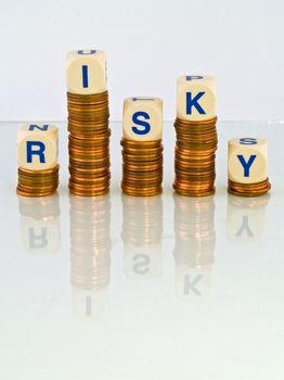 Letter Dice Spelling Risky atop Penny Stacks