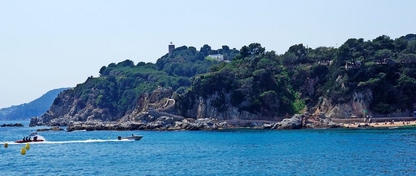 Seascape panorama near Lloret de Mar, Costa Brava, Spain. Fast moving boat in fram