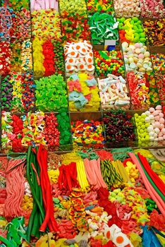 Huge amount of colored sweet things at Barcelona market as background or backdrop.