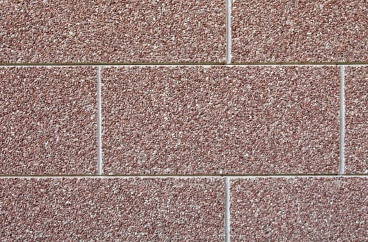 Abstract brown wall texture made of many small stones.