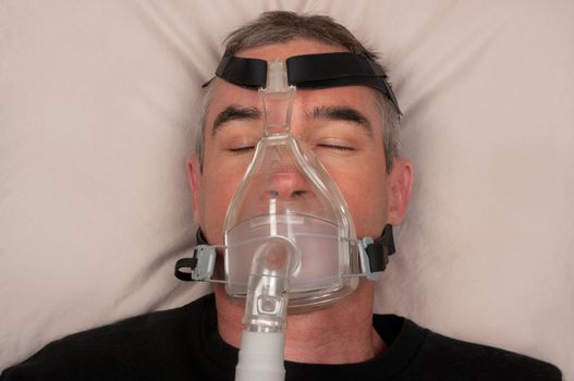 Man with sleep apnea and CPAP machine