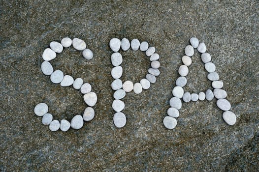 The word Spa made from a pebbles on the surface of boulder