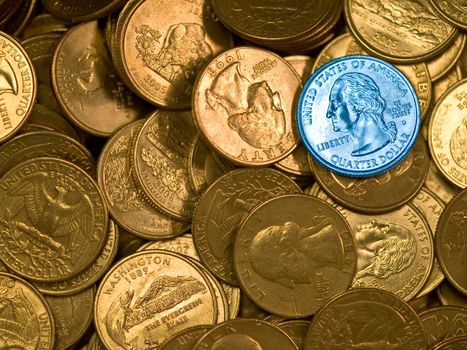 Pile of United States Goldtone Quarters with a Single Blue One 