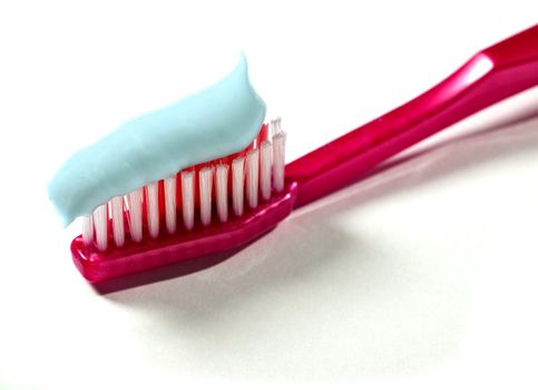 A toothbrush with toothpaste on a white background.