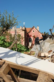Pile of broken furniture and debris in the abandoned neoclassical house garden.