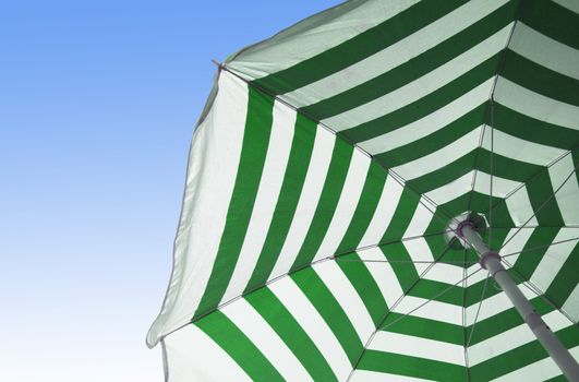 Colorful beach umbrella against sunny blue sky