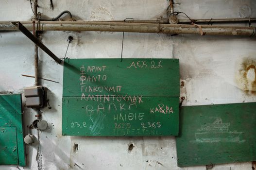Sailing ship drawing in abandoned factory. First names and misspelled insults written in Greek by muslim immigrant children.