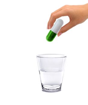 Hand and big pill with glass water - concept