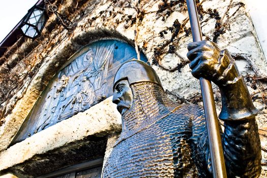 Medieval Bronze Warrior patroles in front of a castle 