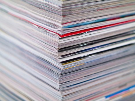 A stack of magazines filling the frame from top to bottom focus on corner edge