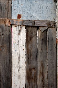Old wooden barn door made from planks and scrap metal. Background texture.