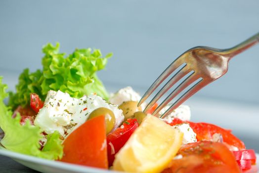 Greek salad on a plate with a fork