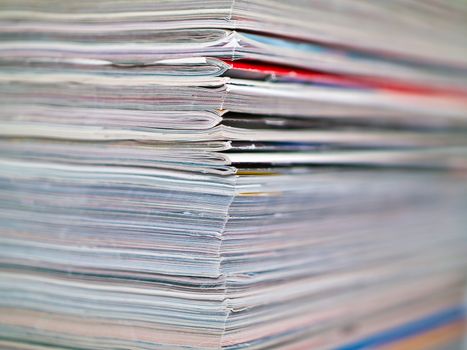 A stack of magazines filling the frame from top to bottom focus on corner edge