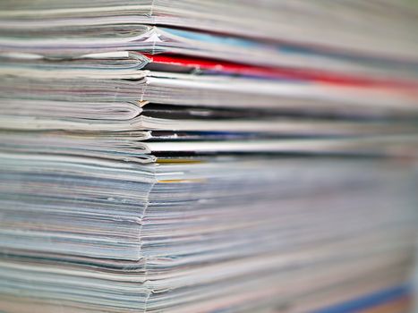 A stack of magazines filling the frame from top to bottom focus on corner edge