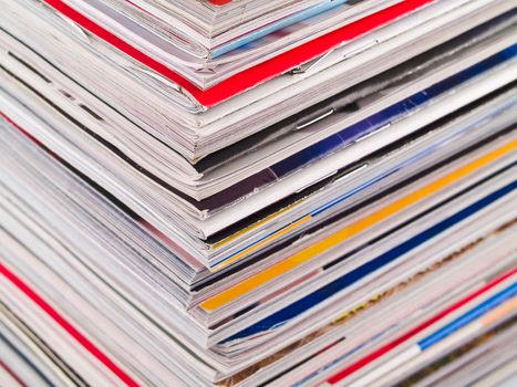 A stack of magazines filling the frame from top to bottom focus on corner edge