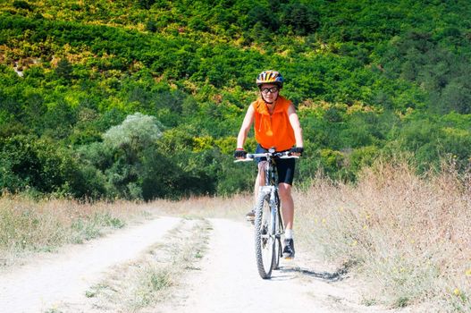 mountain biker on sunny day against forest