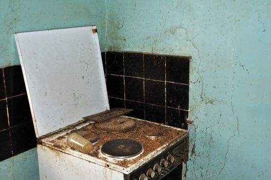Dirty cook stove and moldy wall. Abandoned house kitchen.