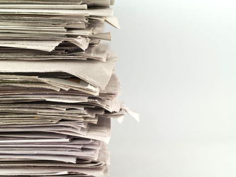 Old newspapers stacked from the top to bottom of the frame isolated on white