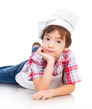 boy dressed as a cook lying on white floor