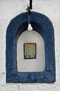 Arched church shrine with framed hagiography depicting two saints. 