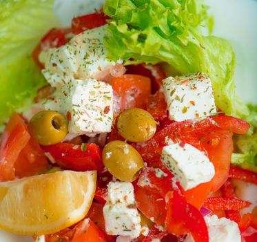Greek salad on a plate with lemon