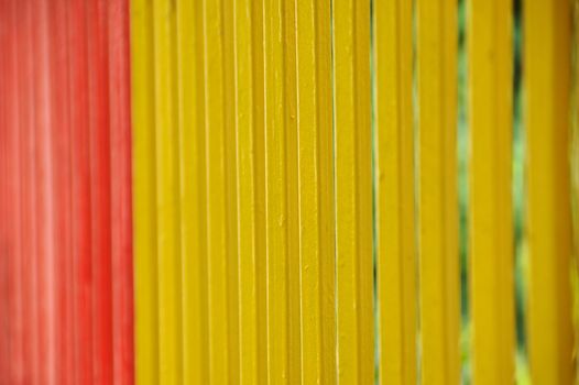 Brightly painted metal fence bars background. Selective focus.