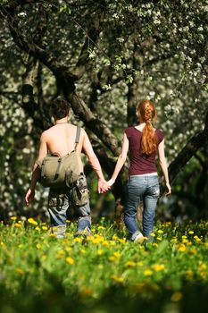 Young man and the girl in a blossoming garden