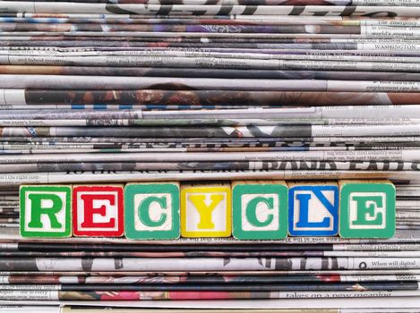 A Pile of Newspapers with the Word RECYCLE in Alpahbet Blacks