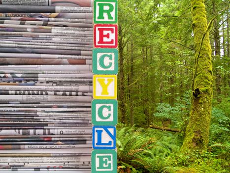 A Pile of Newspapers and Nature Scene with the Word RECYCLE in Alpahbet Blacks