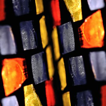 Colorful stained glass abstract illuminated squares. Selective focus.