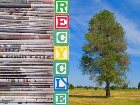 A Pile of Newspapers and Nature Scene with the Word RECYCLE in Alpahbet Blacks