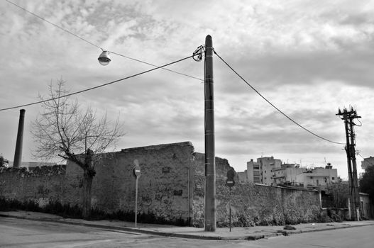 Crumbling factory wall and empty city steets. Black and white.