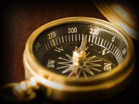 Brass Compass on an old cherrywood table with a dark border