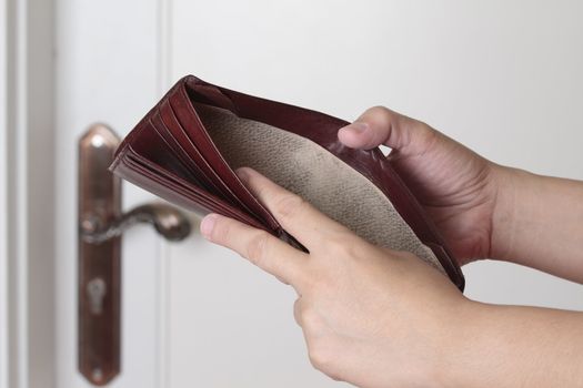 Empty wallet on a house wall background. Bankruptcy concept. 
