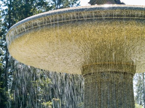 An Outdoor Park Fountain Spraying Water on a Sunny Day