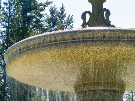 An Outdoor Park Fountain Spraying Water on a Sunny Day