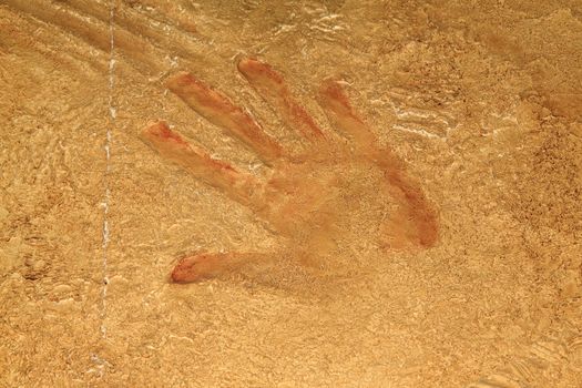 Red hand print on stone background or site