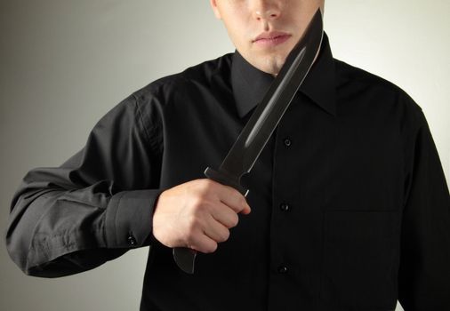 standing man in black with knife concept