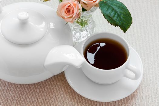 teapot, cup, and  roses on a plate