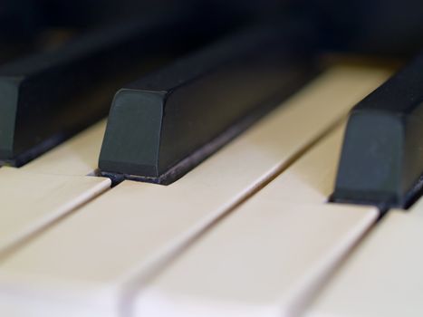 Piano keys of a very well loved and often played piano showing some wear and cracking.