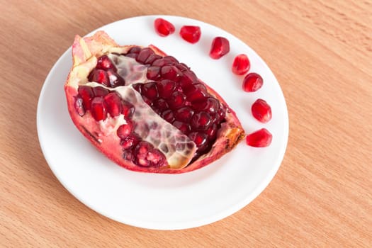 The cut pomegranate and grains on a plate